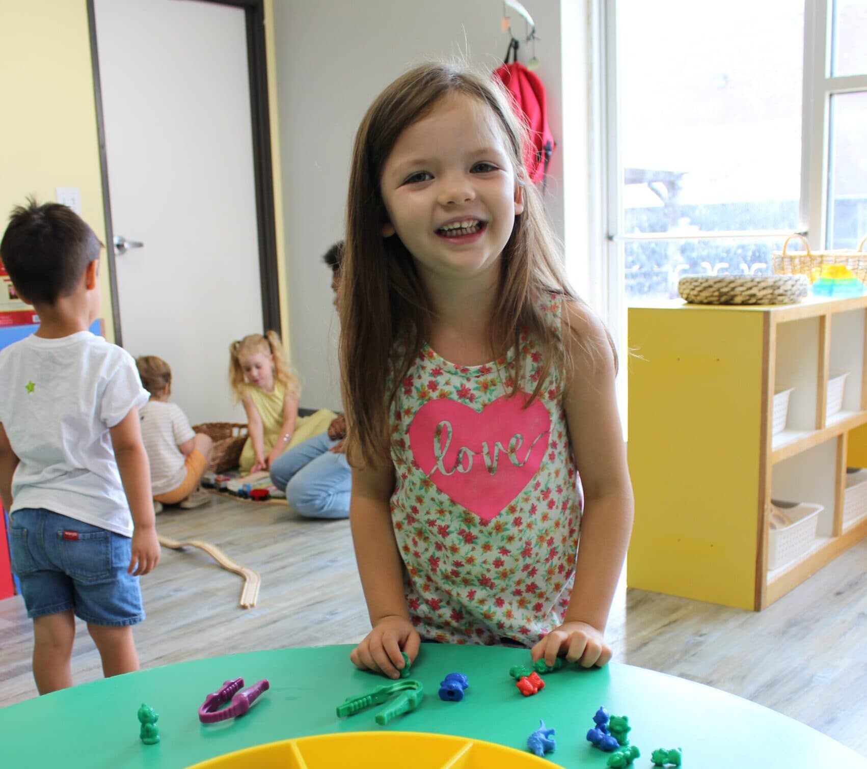 A child smiling at an activity table